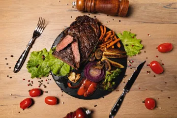Bít tết nướng với rau trên đĩa đá