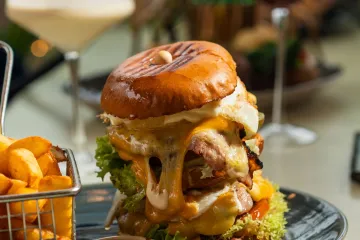 Burger phô mai, khoai chiên và cocktail